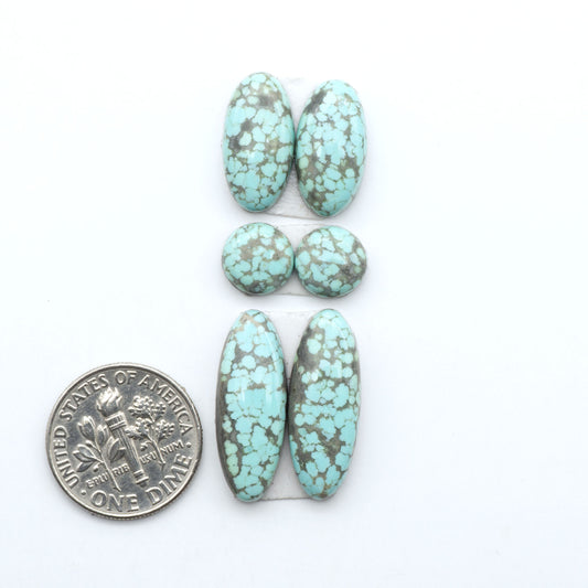 Number 8 Turquoise cabochons, blue and green color with brown matrix, polished stones on a white background, with a US dime for scale