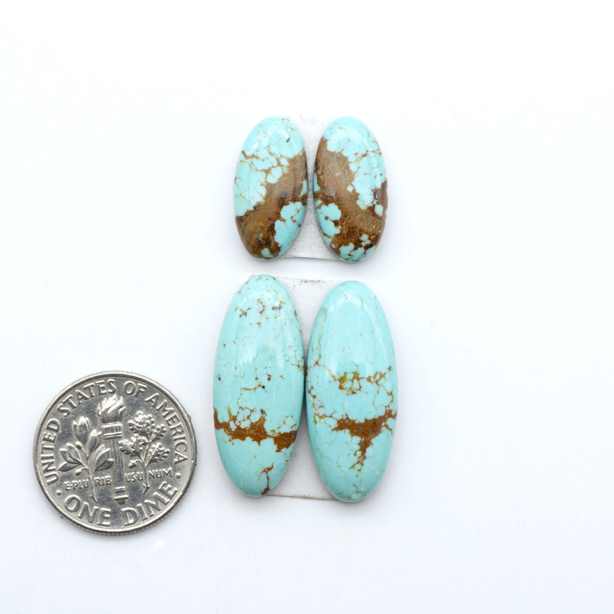Number 8 Turquoise cabochons, blue and green color with brown matrix, polished stones on a white background, with a US dime for scale