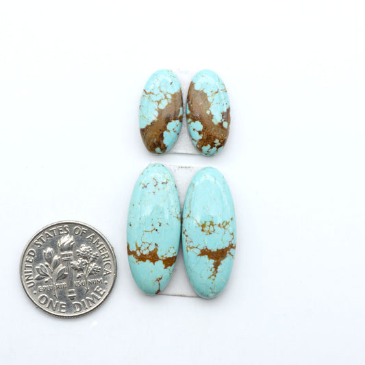 Number 8 Turquoise cabochons, blue and green color with brown matrix, polished stones on a white background, with a US dime for scale