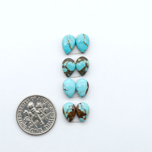 Number 8 Turquoise cabochons, blue and green color with brown matrix, polished stones on a white background, with a US dime for scale