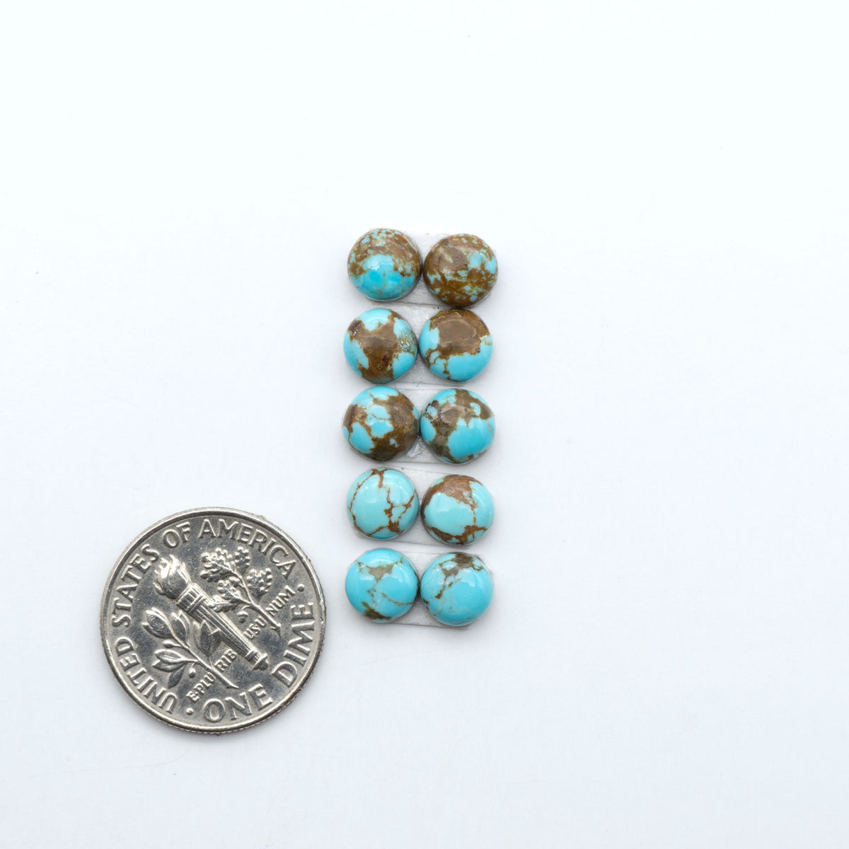 Number 8 Turquoise cabochons, blue and green color with brown matrix, polished stones on a white background, with a US dime for scale