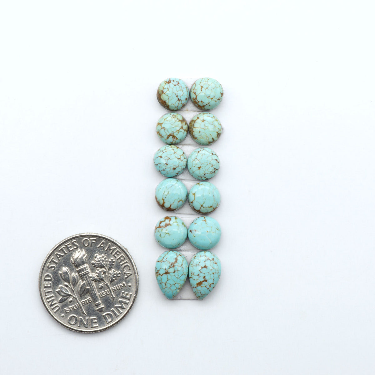 Number 8 Turquoise cabochons, blue and green color with brown matrix, polished stones on a white background, with a US dime for scale