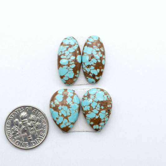 Number 8 Turquoise cabochons, blue and green color with brown matrix, polished stones on a white background, with a US dime for scale