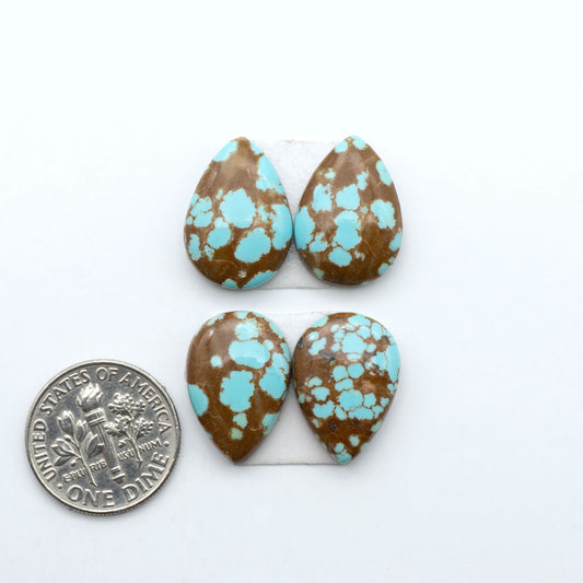 Number 8 Turquoise cabochons, blue and green color with brown matrix, polished stones on a white background, with a US dime for scale
