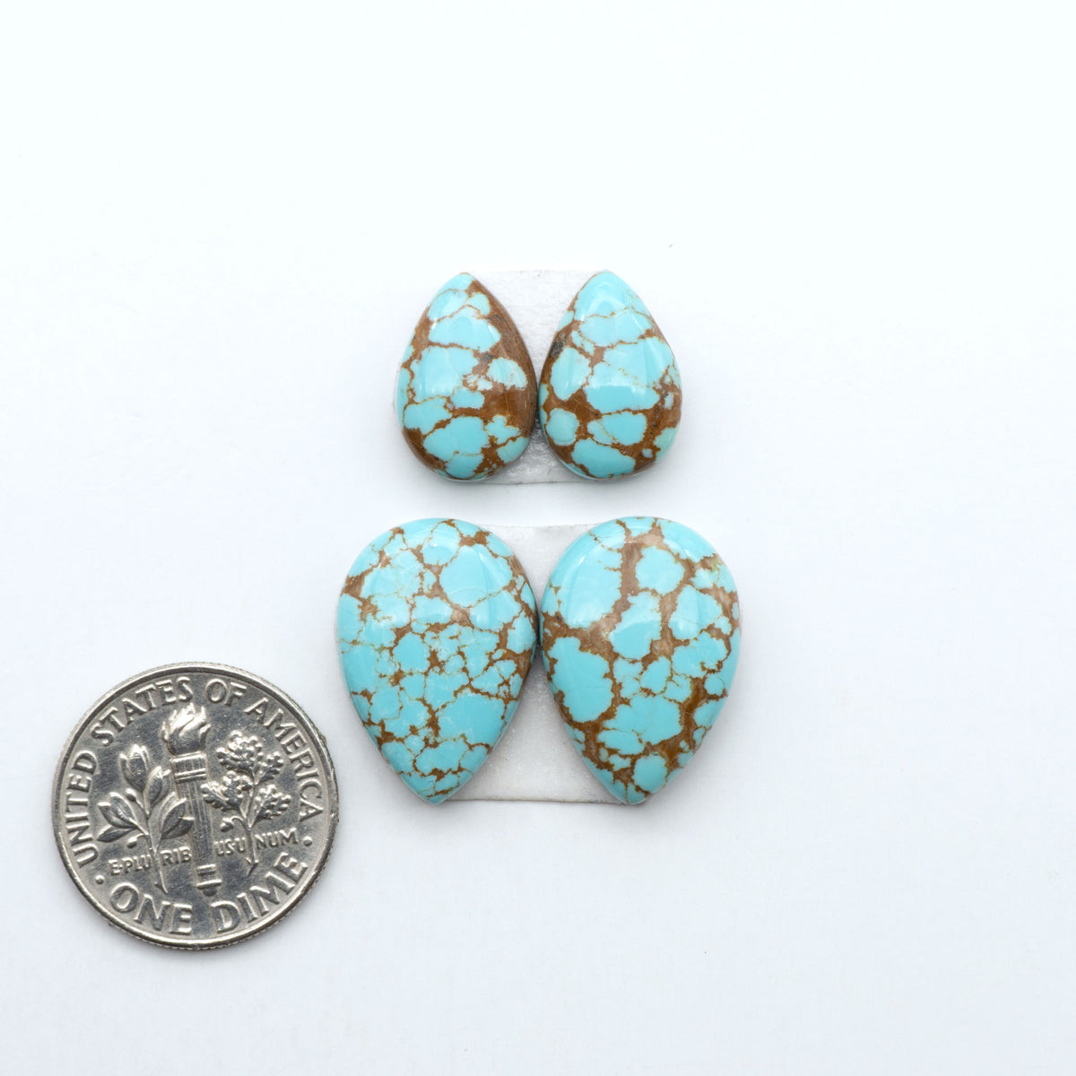 Number 8 Turquoise cabochons, blue and green color with brown matrix, polished stones on a white background, with a US dime for scale
