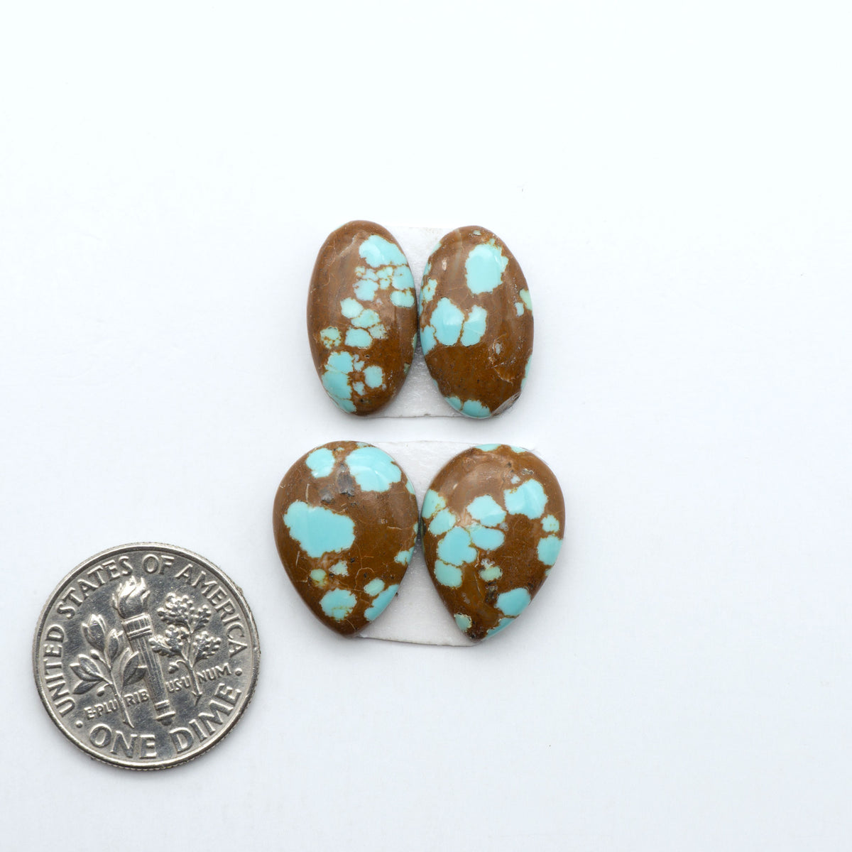 Number 8 Turquoise cabochons, blue and green color with brown matrix, polished stones on a white background, with a US dime for scale