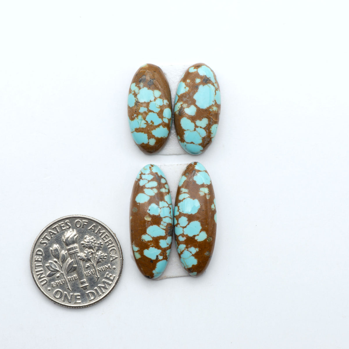 Number 8 Turquoise cabochons, blue and green color with brown matrix, polished stones on a white background, with a US dime for scale
