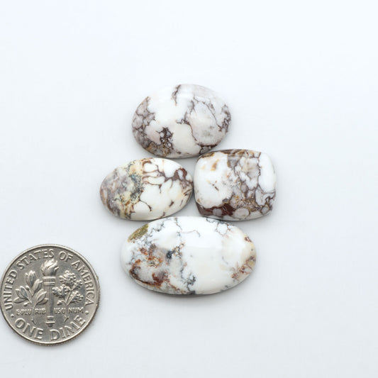 Wild Horse Magnesite cabochons, white gemstones with brown matrix on a white background, with a US dime for scale