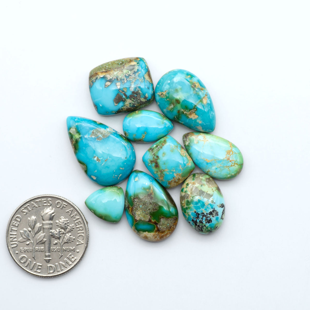 Sonoran Mountain Turquoise cabochons, blue-green color with natural matrix, polished stones on a white background, with a US dime for scale