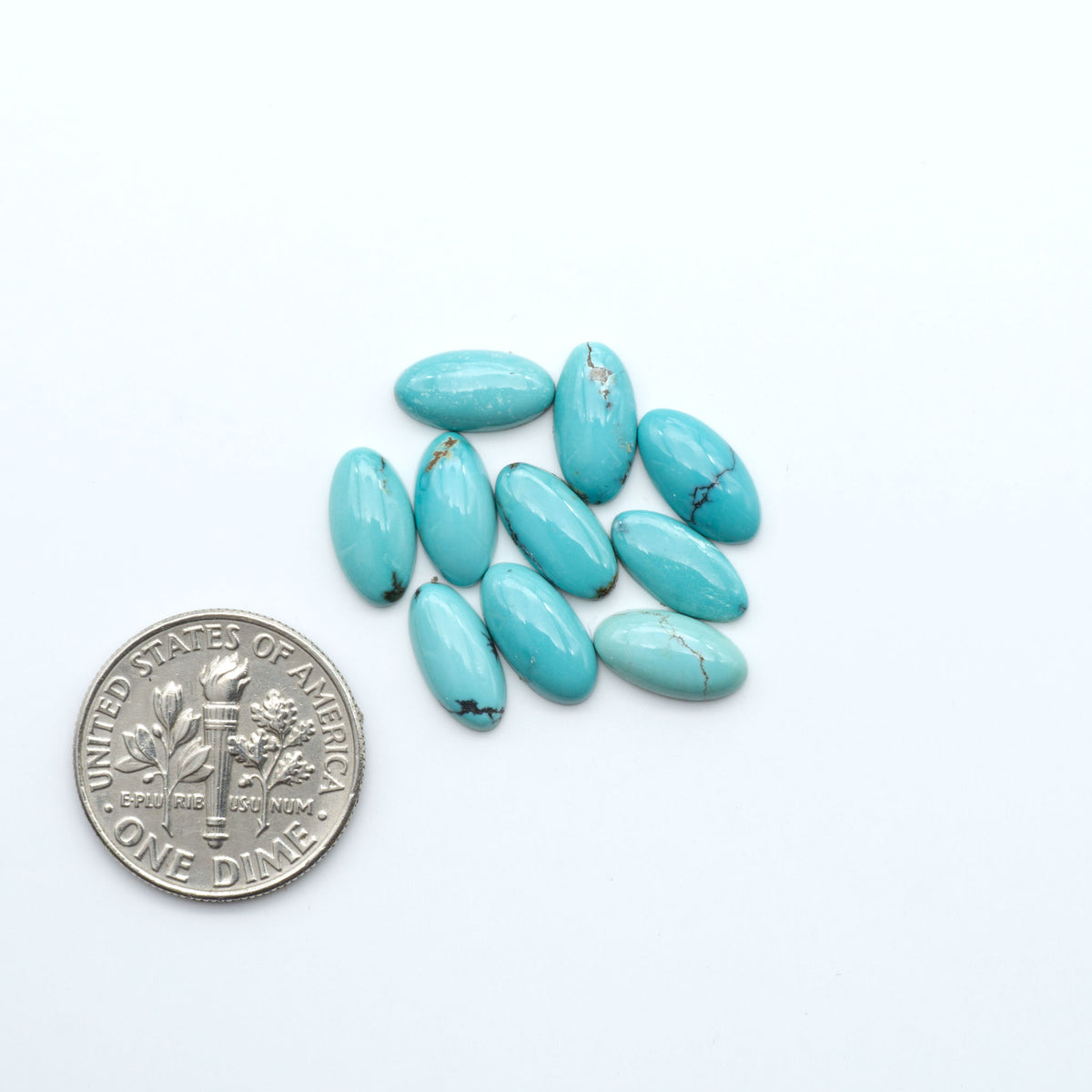 Hubei Cloud Mountain Turquoise cabochons, blue and green color with black matrix, polished stones on a white background, with a US dime for scale