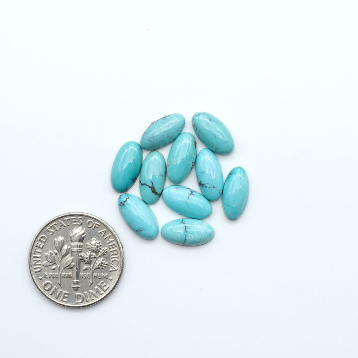 Hubei Cloud Mountain Turquoise cabochons, blue and green color with black matrix, polished stones on a white background, with a US dime for scale