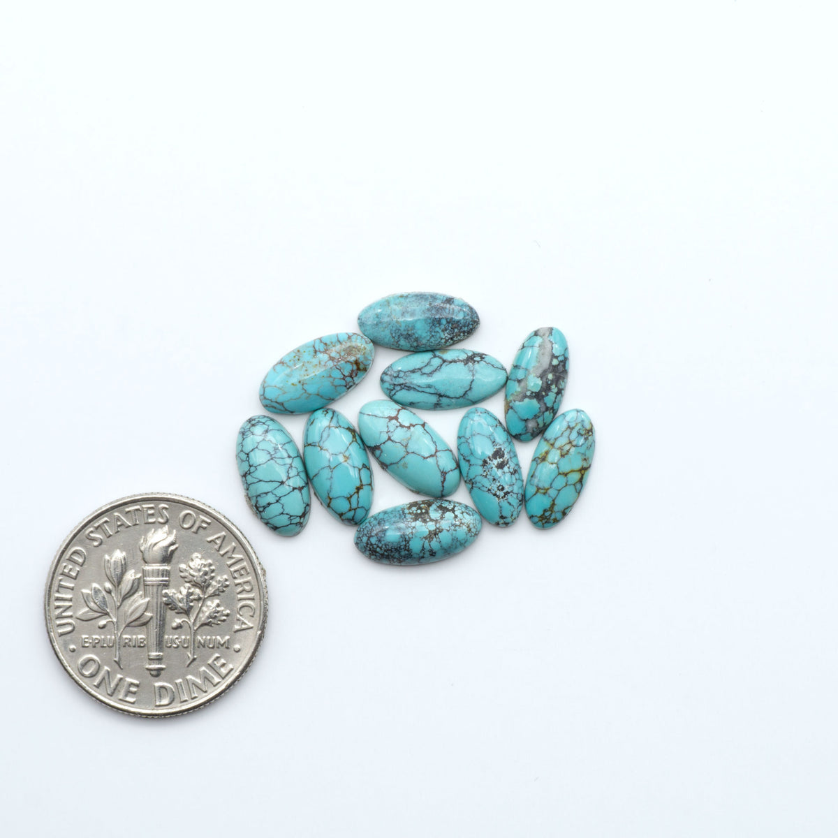 Hubei Cloud Mountain Turquoise cabochons, blue and green color with black matrix, polished stones on a white background, with a US dime for scale