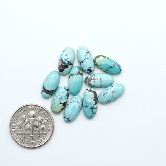 Hubei Cloud Mountain Turquoise cabochons, blue and green color with black matrix, polished stones on a white background, with a US dime for scale
