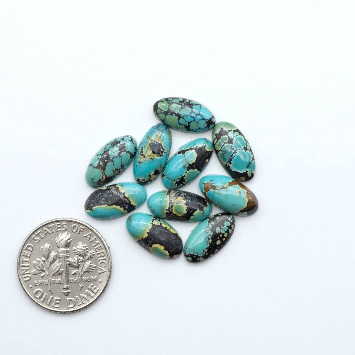 Hubei Cloud Mountain Turquoise cabochons, blue and green color with black matrix, polished stones on a white background, with a US dime for scale