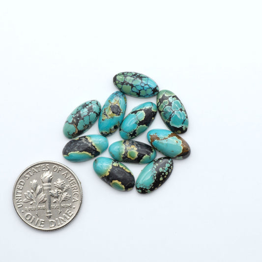 Hubei Cloud Mountain Turquoise cabochons, blue and green color with black matrix, polished stones on a white background, with a US dime for scale