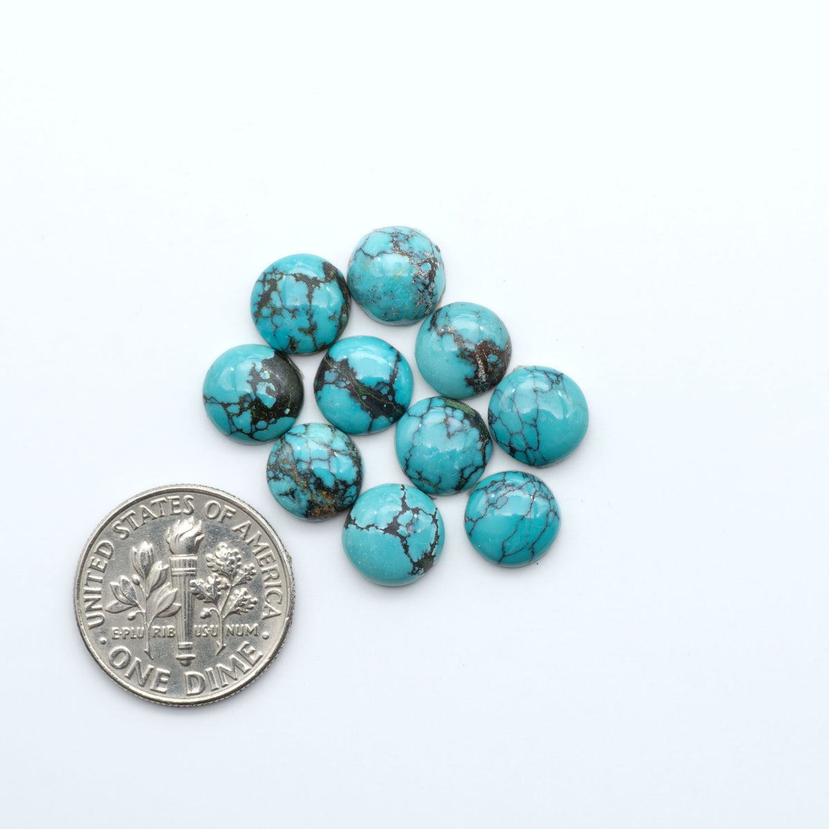 Hubei Cloud Mountain Turquoise cabochons, blue and green color with black matrix, polished stones on a white background, with a US dime for scale