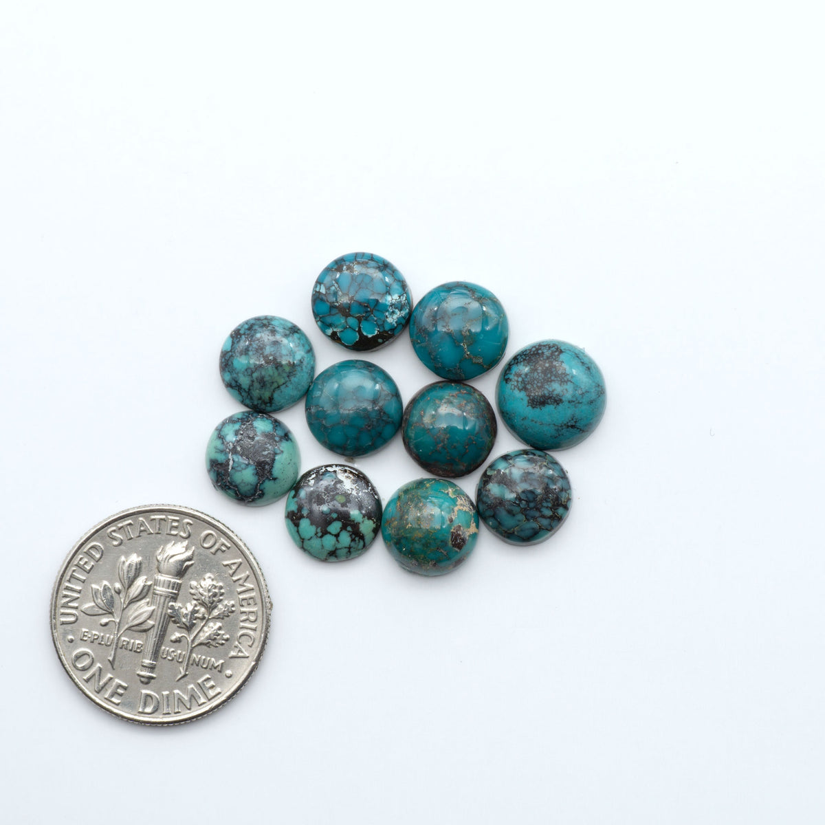 Hubei Cloud Mountain Turquoise cabochons, blue and green color with black matrix, polished stones on a white background, with a US dime for scale