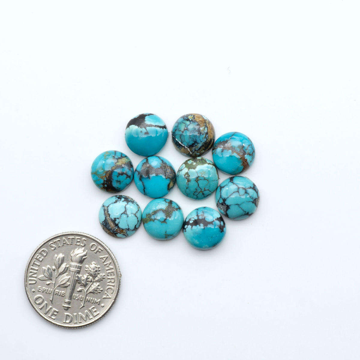 Hubei Cloud Mountain Turquoise cabochons, blue and green color with black matrix, polished stones on a white background, with a US dime for scale