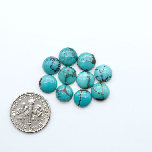 Hubei Cloud Mountain Turquoise cabochons, blue and green color with black matrix, polished stones on a white background, with a US dime for scale