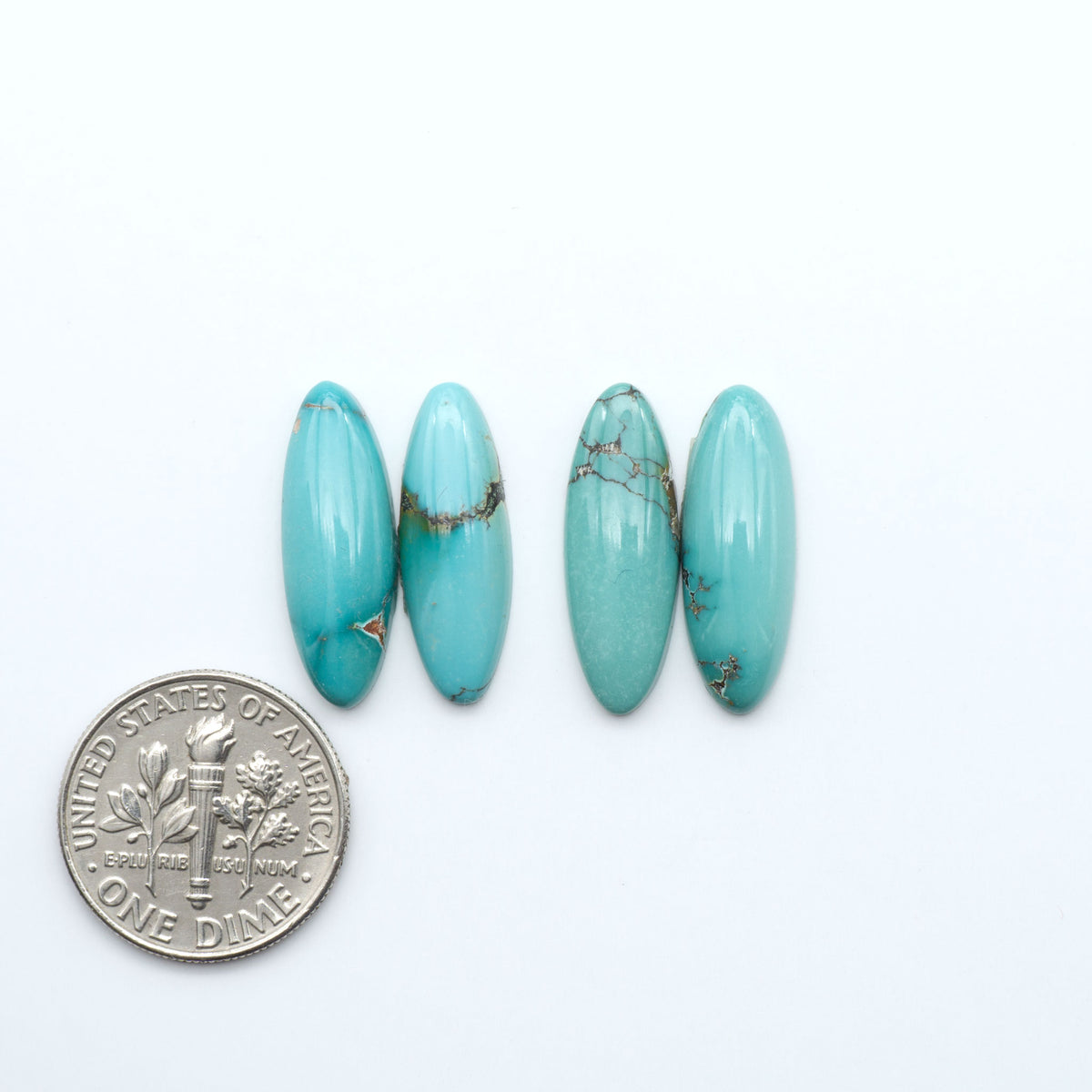 Hubei Cloud Mountain Turquoise cabochons, blue and green color with black matrix, polished stones on a white background, with a US dime for scale