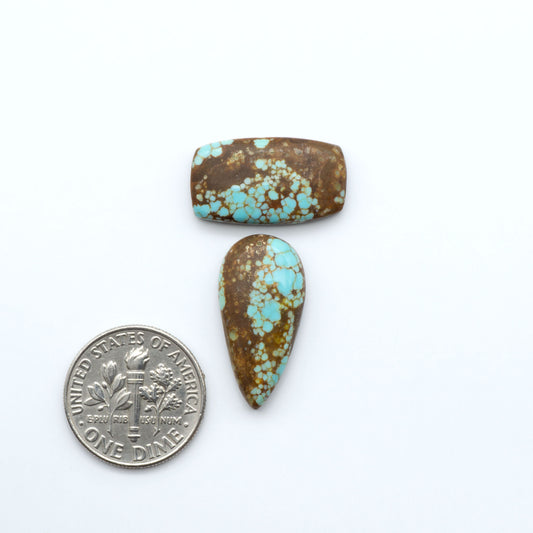 Number 8 Turquoise cabochons, blue and green color with brown matrix, polished stones on a white background, with a US dime for scale