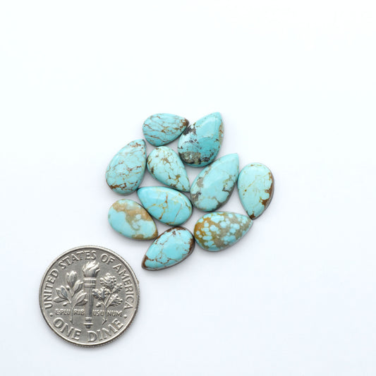 Number 8 Turquoise cabochons, blue and green color with brown matrix, polished stones on a white background, with a US dime for scale