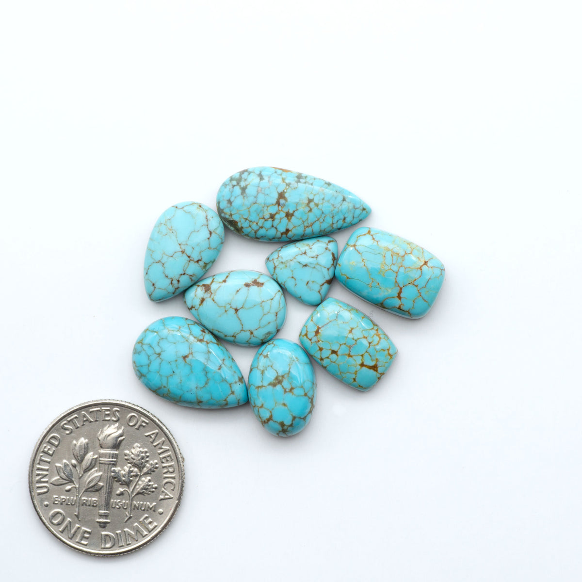Number 8 Turquoise cabochons, blue and green color with brown matrix, polished stones on a white background, with a US dime for scale