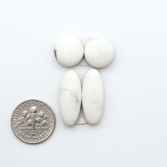 White Buffalo stone cabochons, white stone with black matrix, polished stones on a white background, with a US dime for scale