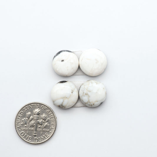White Buffalo stone cabochons, white stone with black matrix, polished stones on a white background, with a US dime for scale