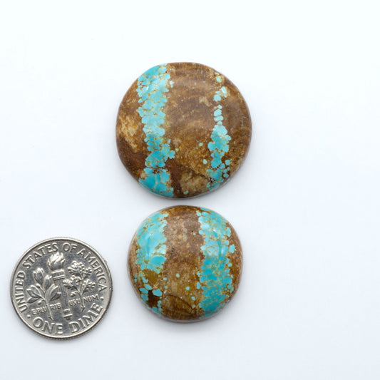Number 8 Turquoise cabochons, blue and green color with brown matrix, polished stones on a white background, with a US dime for scale