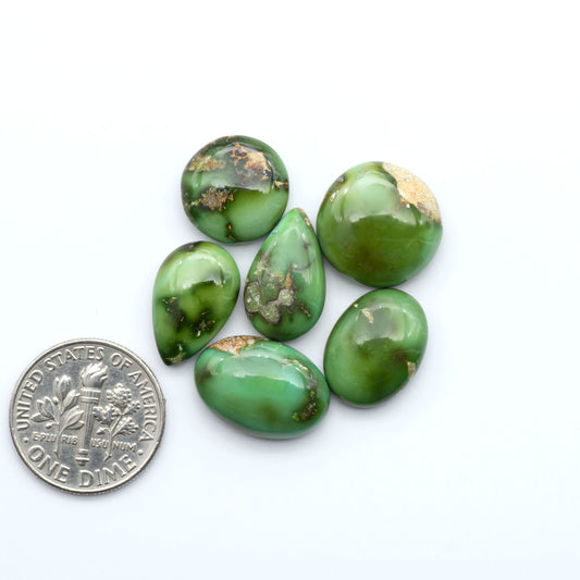 Sonoran Mountain Turquoise cabochons, blue-green color with natural matrix, polished stones on a white background, with a US dime for scale