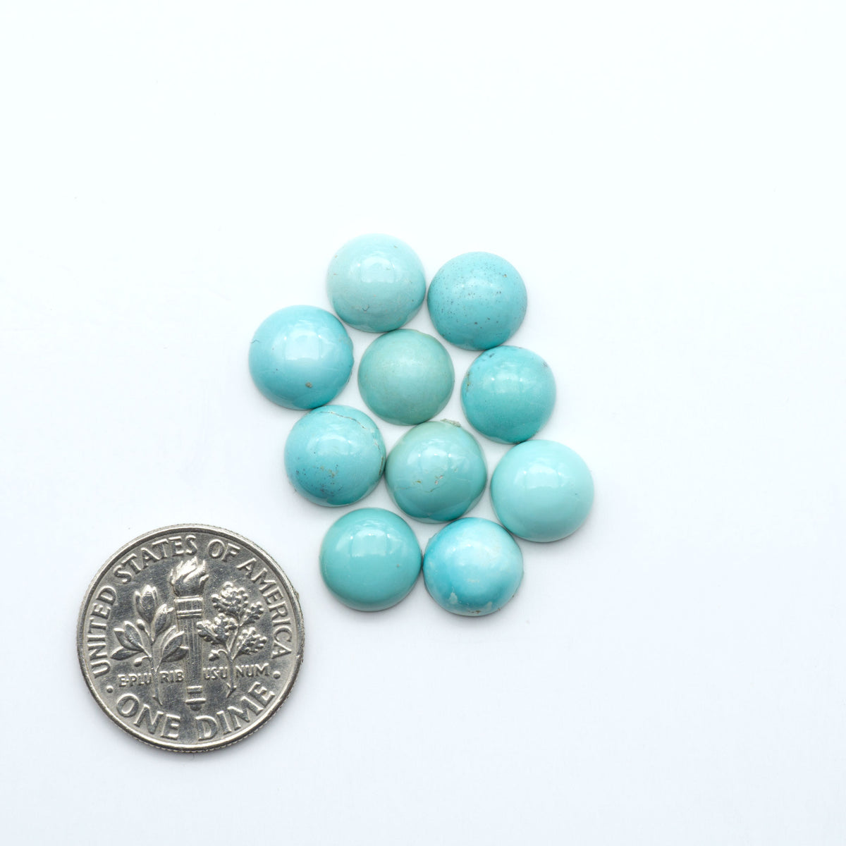 Hubei Cloud Mountain Turquoise cabochons, blue and green color with black matrix, polished stones on a white background, with a US dime for scale