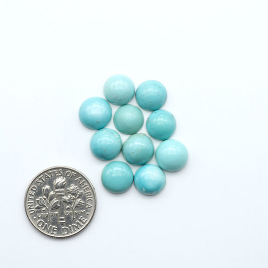 Hubei Cloud Mountain Turquoise cabochons, blue and green color with black matrix, polished stones on a white background, with a US dime for scale