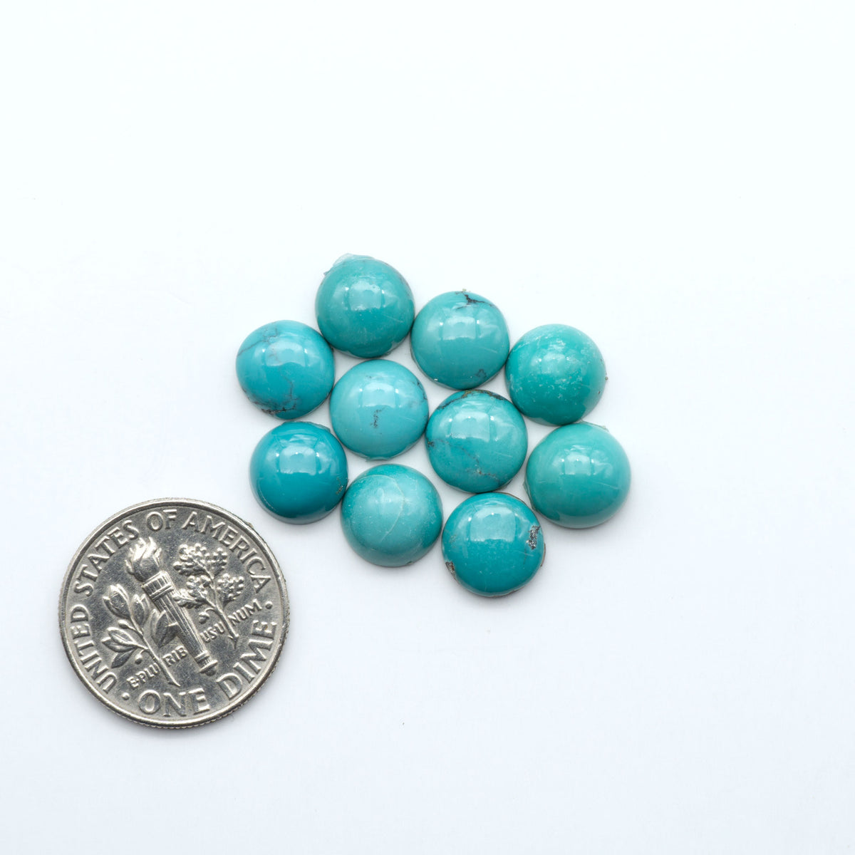 Hubei Cloud Mountain Turquoise cabochons, blue and green color with black matrix, polished stones on a white background, with a US dime for scale