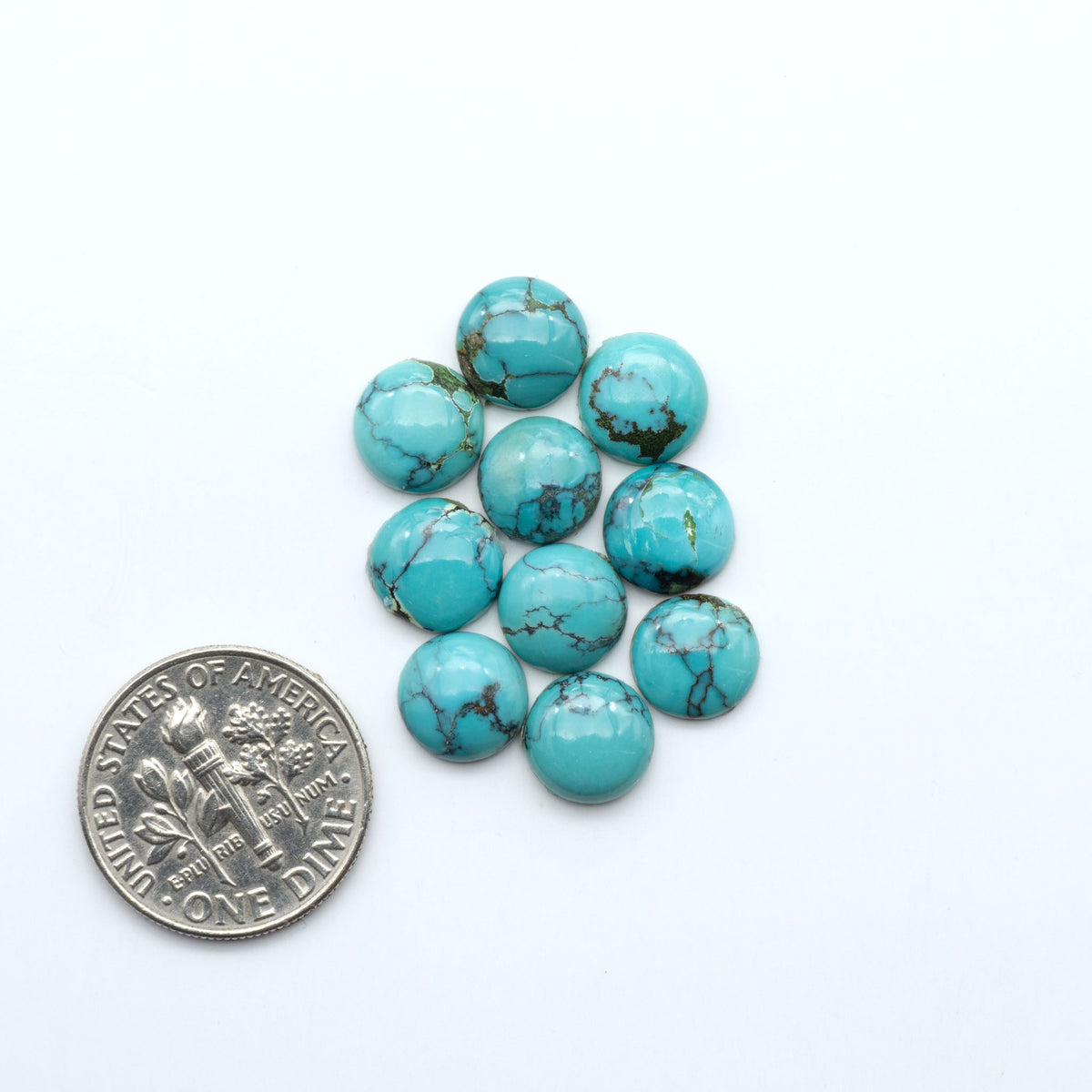 Hubei Cloud Mountain Turquoise cabochons, blue and green color with black matrix, polished stones on a white background, with a US dime for scale
