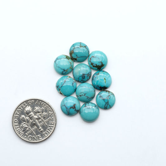Hubei Cloud Mountain Turquoise cabochons, blue and green color with black matrix, polished stones on a white background, with a US dime for scale