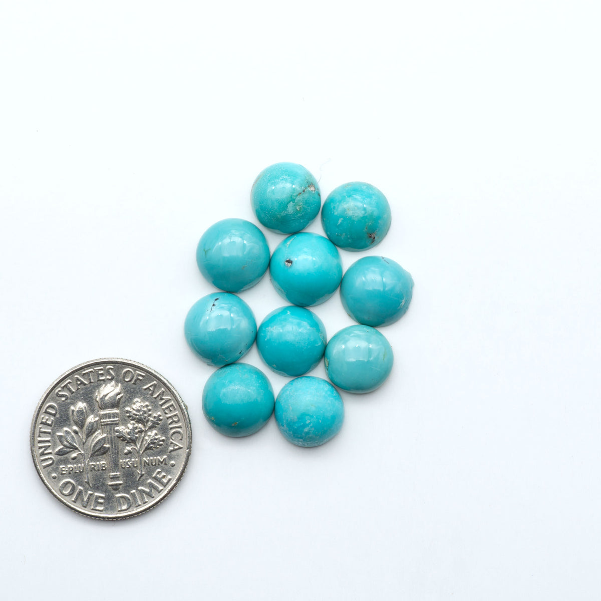Hubei Cloud Mountain Turquoise cabochons, blue and green color with black matrix, polished stones on a white background, with a US dime for scale