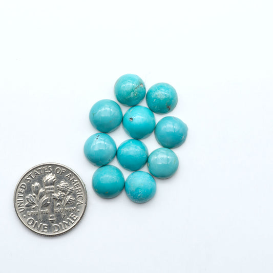 Hubei Cloud Mountain Turquoise cabochons, blue and green color with black matrix, polished stones on a white background, with a US dime for scale