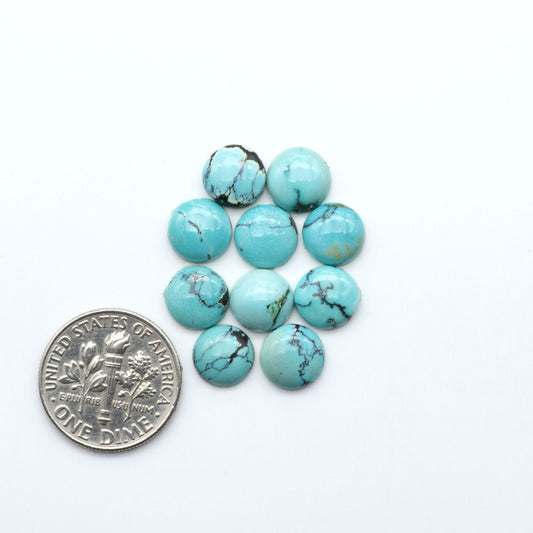 Hubei Cloud Mountain Turquoise cabochons, blue and green color with black matrix, polished stones on a white background, with a US dime for scale