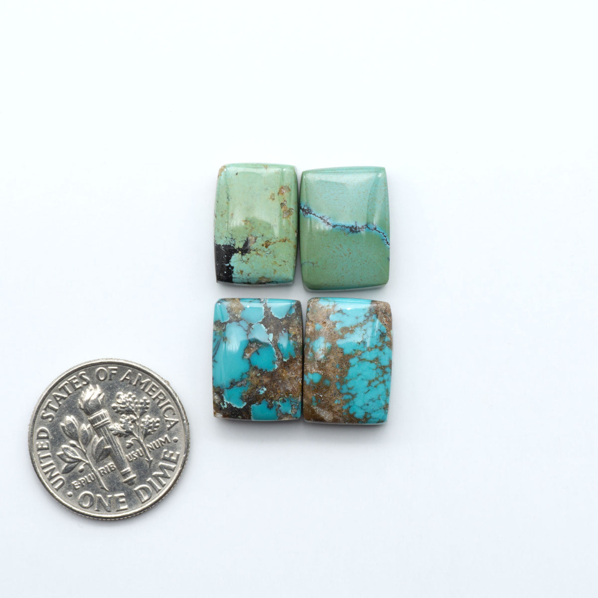 Hubei Cloud Mountain Turquoise cabochons, blue and green color with black matrix, polished stones on a white background, with a US dime for scale