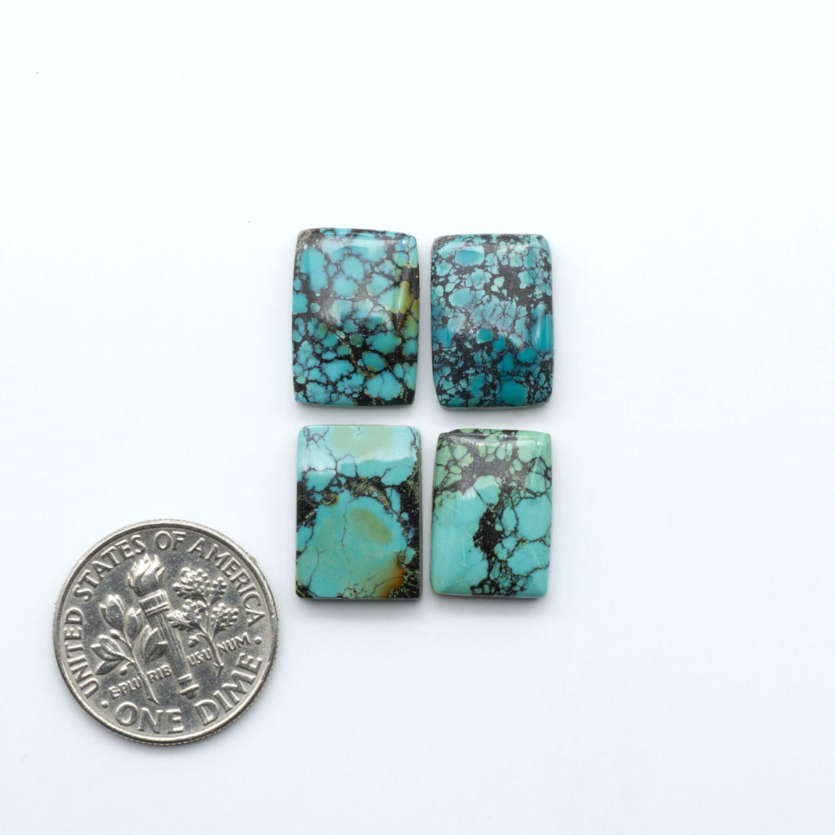 Hubei Cloud Mountain Turquoise cabochons, blue and green color with black matrix, polished stones on a white background, with a US dime for scale