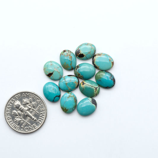Hubei Cloud Mountain Turquoise cabochons, blue and green color with black matrix, polished stones on a white background, with a US dime for scale