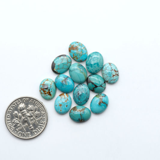 Hubei Cloud Mountain Turquoise cabochons, blue and green color with black matrix, polished stones on a white background, with a US dime for scale