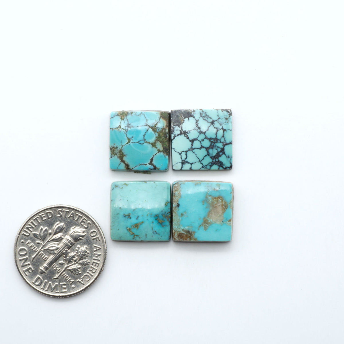Hubei Cloud Mountain Turquoise cabochons, blue and green color with black matrix, polished stones on a white background, with a US dime for scale