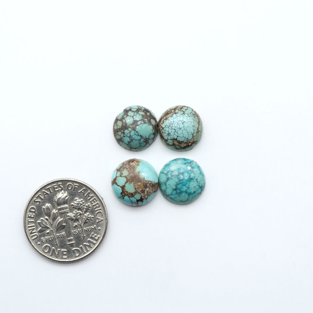 Hubei Cloud Mountain Turquoise cabochons, blue and green color with black matrix, polished stones on a white background, with a US dime for scale