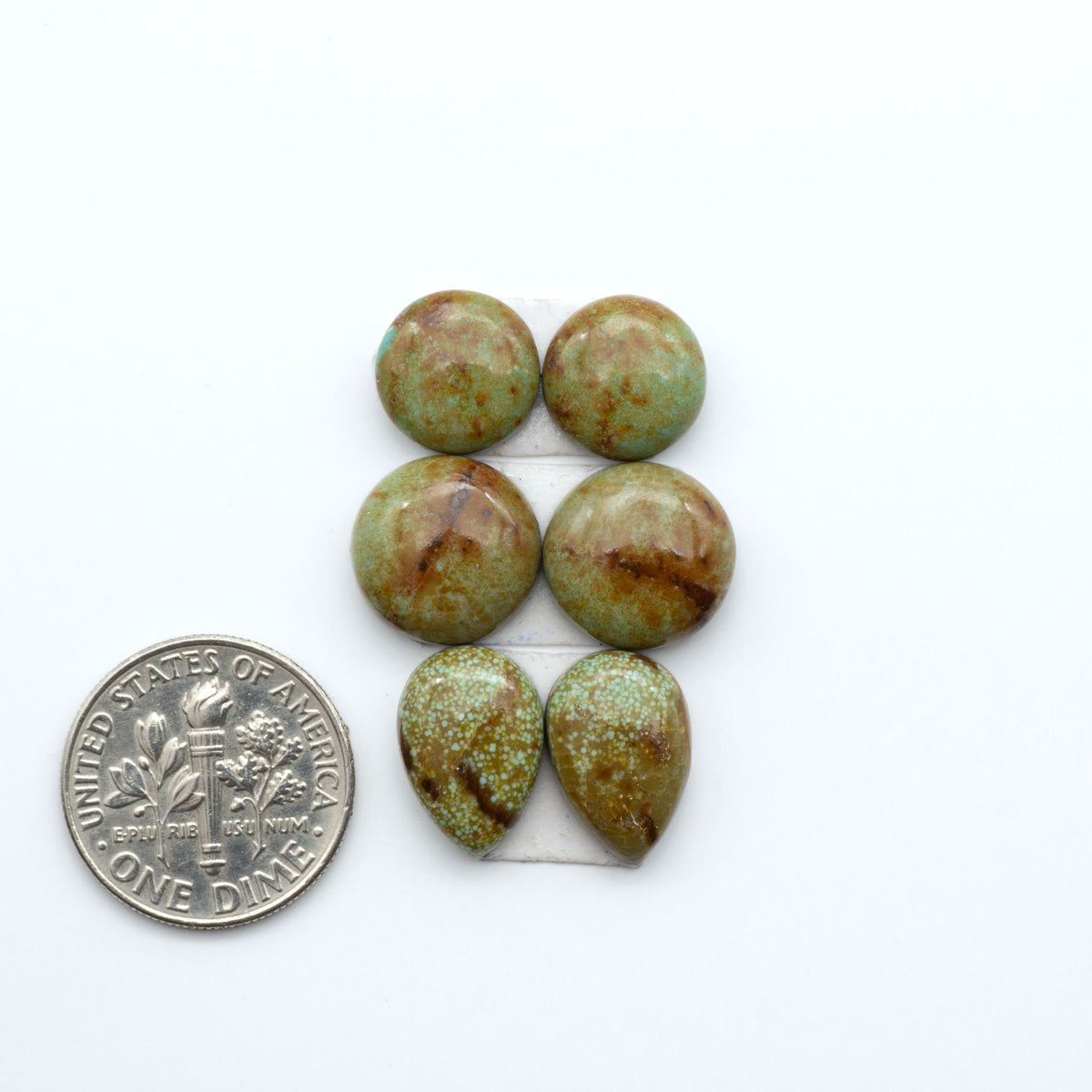 Number 8 Turquoise cabochons, blue and green color with brown matrix, polished stones on a white background, with a US dime for scale
