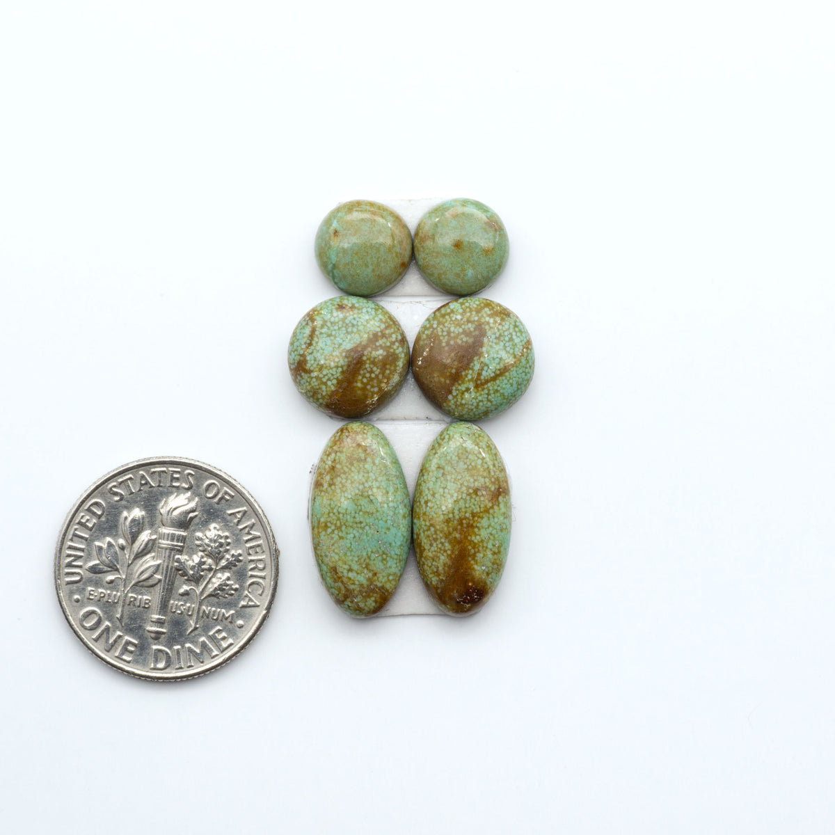 Number 8 Turquoise cabochons, blue and green color with brown matrix, polished stones on a white background, with a US dime for scale
