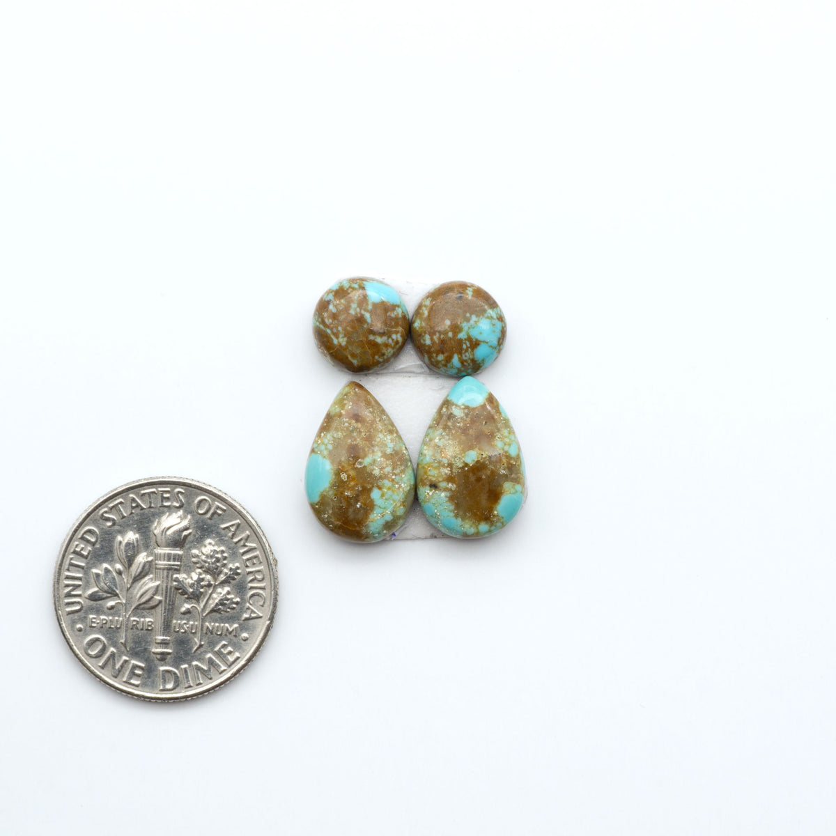 Number 8 Turquoise cabochons, blue and green color with brown matrix, polished stones on a white background, with a US dime for scale