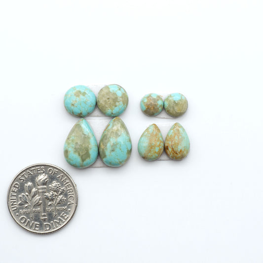 Number 8 Turquoise cabochons, blue and green color with brown matrix, polished stones on a white background, with a US dime for scale