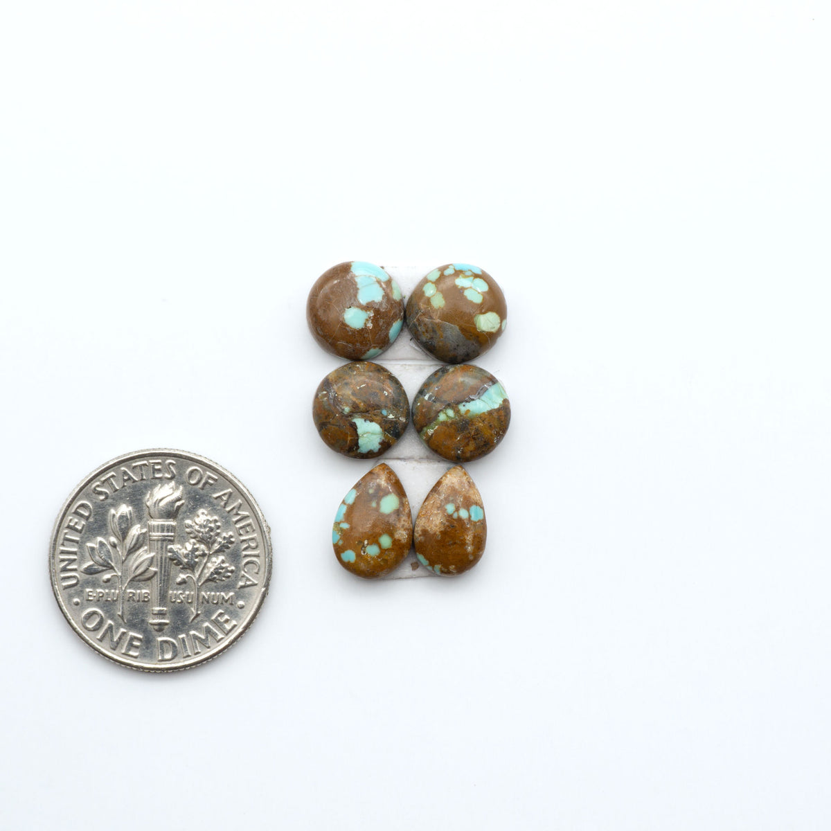 Number 8 Turquoise cabochons, blue and green color with brown matrix, polished stones on a white background, with a US dime for scale